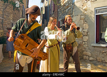 Musiciens en costumes médiévaux, à l'orgue de barbarie et shawms dans les rues du village médiéval d'Aiguèze dans l Banque D'Images