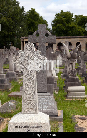 Croix en pierre du Souvenir et des statues sur les tombes dans la section centrale de Brompton Cemetery, près de les colonnades. Banque D'Images