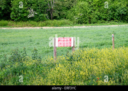 Avis de propriété privée rouge avec du texte blanc debout sur les terres agricoles en UK Banque D'Images