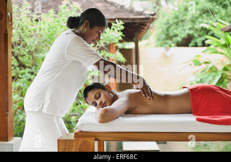 Une femme reçoit un massage des tissus en profondeur au Spa Sahana, Saman Villas, Aturuwella, Bentota, Sri Lanka. Banque D'Images