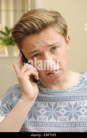 Teenage boy parle sur son téléphone mobile Banque D'Images