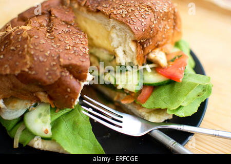 Big hamburger en tranches sur une assiette avec salade Banque D'Images