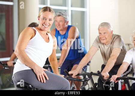 Cadres supérieurs de spinning class in gym avec female fitness trainer Banque D'Images
