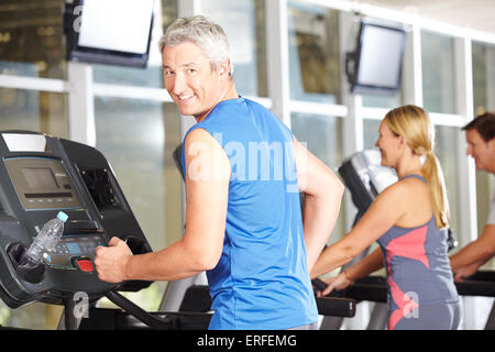 Happy senior man la formation dans un centre de remise en forme sur le tapis roulant Banque D'Images