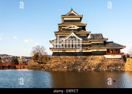 Une attraction touristique populaire, le donjon du château de Matsumoto au Japon dans l'heure d'or de l'après-midi juste avant le coucher du soleil avec un fond bleu ciel. Banque D'Images