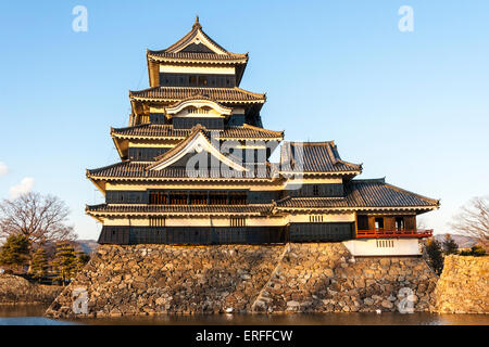 Une attraction touristique populaire, le donjon du château de Matsumoto au Japon dans l'heure d'or de l'après-midi juste avant le coucher du soleil avec un fond bleu ciel. Banque D'Images