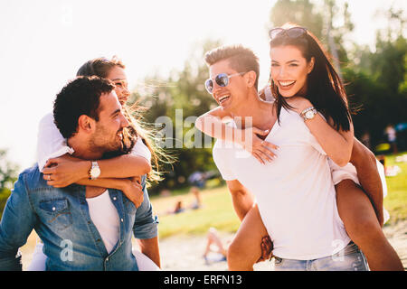 Les jeunes couples s'amusant sur la plage Banque D'Images