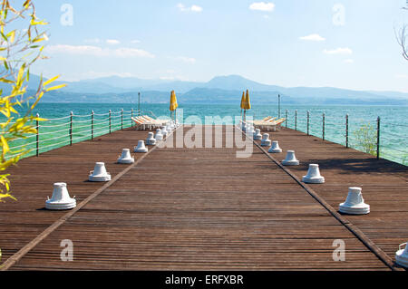 Jetée en bois avec parasol à Sirmione, une ville touristique sur le lac de Garde, Brescia, Italie. Prises le 25 mai 2014. Banque D'Images