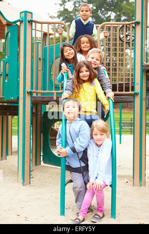 Les jeunes enfants assis sur Escalade en aire de jeux Banque D'Images