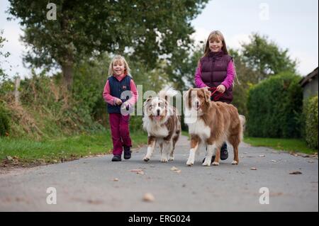 Les filles avec bergers australiens Banque D'Images