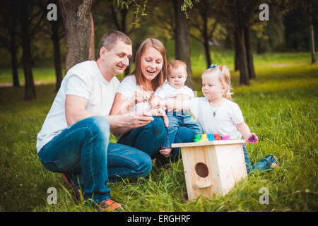 Famille heureuse avec nichoir et peintures Banque D'Images