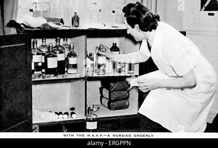 Les femmes Auxiliary Air Force (WAAF) - Une infirmière prend une bouteille d'une armoire à pharmacie. Banque D'Images