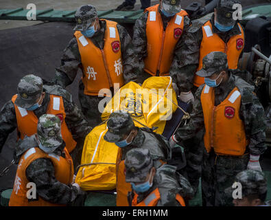 Jianli, Chine. 3 juin, 2015. Les sauveteurs tentent de transporter un corps de la victime à l'emplacement de la navire renversé dans la section Jianli de la rivière Yangtze, le centre de la Chine, Province de Hubei. Il y a eu plus de 450 personnes à bord du navire à passagers, le Eastern Star lorsqu'il sombra, "dans une ou deux minutes après avoir été frappé par une tornade au Jianli, Province de Hubei, selon le capitaine du navire et le chef mécanicien, qui ont tous deux survécu. Source : Xinhua/Alamy Live News Banque D'Images