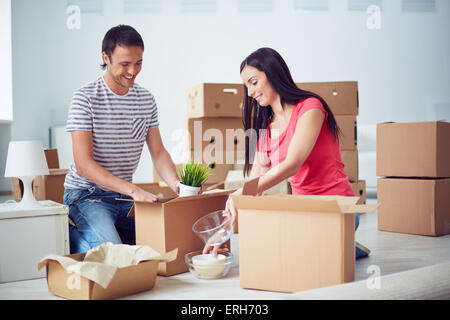 Jeune couple unpacking boxes après la dépose à nouveau house Banque D'Images