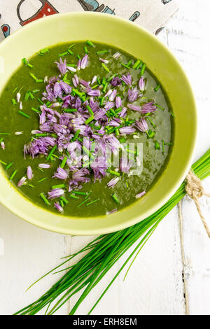 De blettes et pommes de terre Soupe crème de ciboulette ciboulette en fleurs comestibles avec bol en céramique verte Banque D'Images