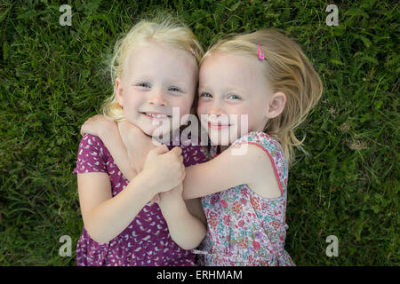 Deux girls lying on the grass hugging Banque D'Images