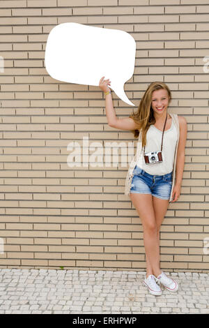 Belle et jeune adolescent tenant une pensée ballon, en face d'un mur de briques Banque D'Images