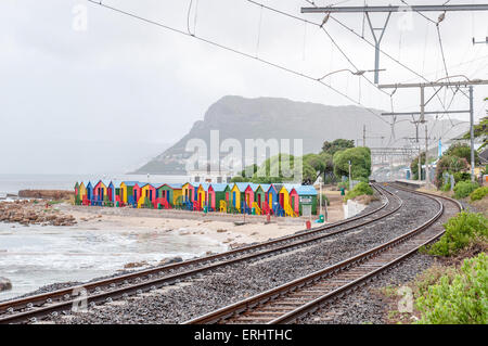 Multi-couleur des cabines de plage à St James à Cape Town, Western Cape Province de l'Afrique du Sud. Le chemin de fer et la gare est visible Banque D'Images