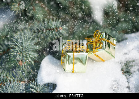 Coffrets cadeaux sur l'arbre de Noël avec des chutes de neige Banque D'Images