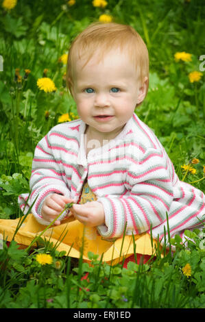 Outdoor portrait of a cute little baby in the grass Banque D'Images