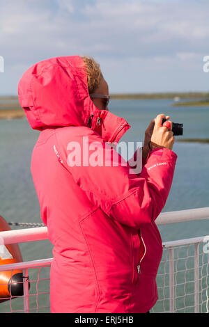 Jeune femme prenant une photo à bord du ferry Wightlink entre Lymington et Yarmouth, île de Wight, Hampshire Royaume-Uni, en mai Banque D'Images