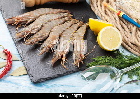 Matières premières fraîches crevettes géantes et du matériel de pêche sur table en bois Banque D'Images