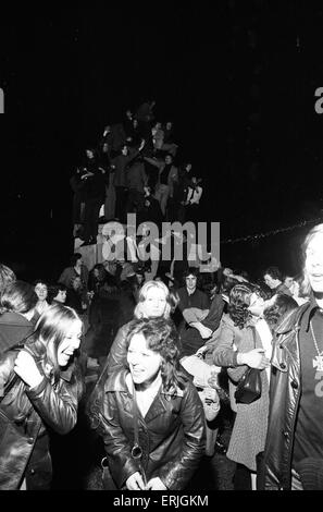 Une foule de jeunes gens heureux saluer la nouvelle année dans les esprits dans Broadgate, Coventry. Mais pour un couple c'est une occasion bien plus personnel. 1er janvier 1973. Banque D'Images