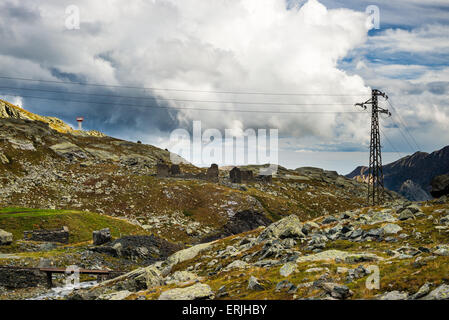 Ligne d'alimentation électrique à haute tension dans les Alpes italiennes dans le pittoresque paysage de haute montagne et dramatique ciel d'orage. Banque D'Images