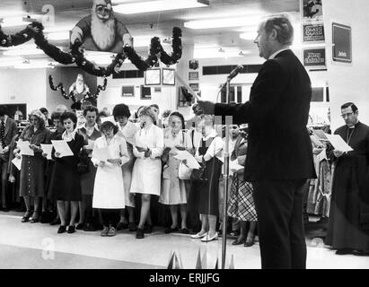 Personnel de l'Owen Owen recueillir dans l'espace de vente pour le traditionnel Carol Service . 12 Décembre 1978 Banque D'Images