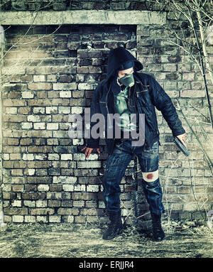 Désastre environnemental. Survivant post apocalyptique en masque à gaz holding hand gun Banque D'Images