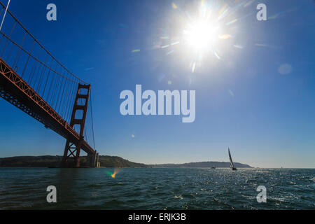 Soleil éblouissant brille sur l'eau, voilier, et Golden Gate Bridge à San Francisco Banque D'Images