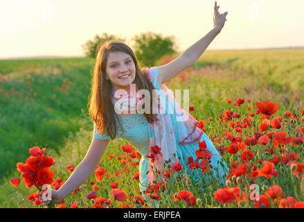 Belle jeune fille en champ de coquelicots Banque D'Images