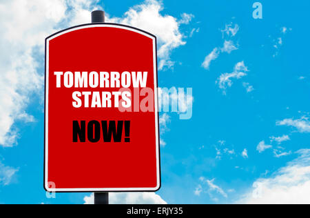 Demain commence maintenant motivational quote écrit sur red road sign isolated sur fond de ciel bleu clair Banque D'Images