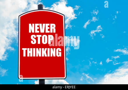 Ne jamais cesser de penser motivational quote écrit sur red road sign isolated over clair fond de ciel bleu. Concept image avec copie espace disponible Banque D'Images