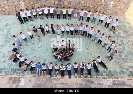 Kaili, dans la province du Guizhou en Chine. 2 juin, 2015. Les diplômés de Kaili n° 3 Middle School et leur enseignant posent pour une photo dans l'obtention du diplôme Kaili, dans la province du Guizhou en Chine du sud-ouest, le 2 juin 2015. Comme l'obtention du diplôme, les diplômés saison sont occupés à prendre des photos créatives au campus. © Wu Jibin/Xinhua/Alamy Live News Banque D'Images