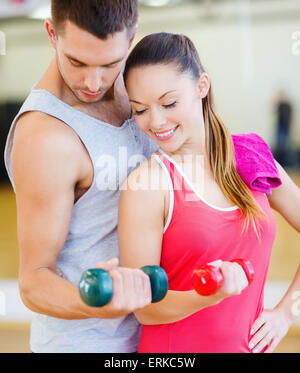 Deux smiling people working out with dumbbells Banque D'Images