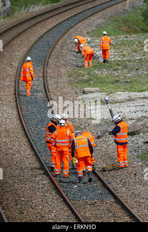 Plusieurs ingénieurs de réseau ferroviaire et ingénieur ferroviaire sur Settle Carlisle Line, Santé et sécurité pour les hommes au travail à Tebay Cumbria travaillant sur l'entretien des voies ferrées. Inspecteurs, ingénieurs de sécurité, employés, travailleurs ferroviaires, ouvriers, renouvellement des lignes de chemin de fer et inspecteurs de l'infrastructure inspectant et mesurant la voie de transport de marchandises au sommet de AIS Gill. Le sommet du chemin de fer à 1 169 pieds (356 mètres) est au nord de Garsdale est la plus haute ligne principale d'Angleterre, et transporte des trains de marchandises lourdement chargés. Banque D'Images