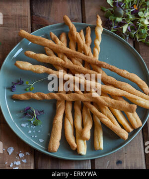 Gressins italiens sur une plaque bleue avec des herbes. Banque D'Images