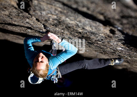 L'ascension d'une femme petite fissure au-dessus de son partenaire d'assurage et une rivière de Yosemite National Park, en Californie. Banque D'Images