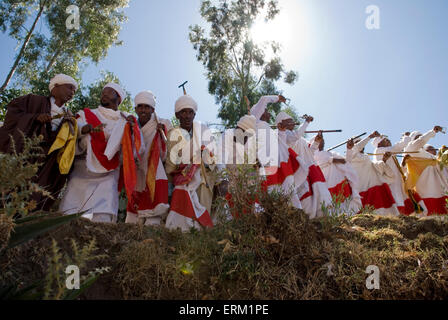 Groupe de prêtres vêtus de vêtements de cérémonie en chantant et dansant en procession lors du festival Timkat à Lalibela, Ethiopie Banque D'Images