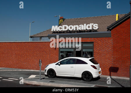 Le conducteur d'une voiture en attente d'être servis à la trappe du lecteur dans d'un restaurant McDonalds Banque D'Images