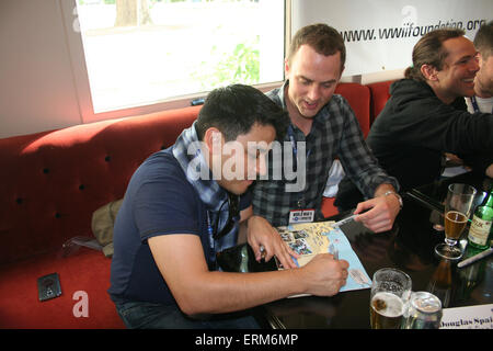 Bayeux, Normandie, France. 4e juin 2015. Les acteurs de la série télévisée Band of Brothers, a signé des autographes pour les fans de partout dans le monde, dans le cadre de la D-Day Festival 2015. Cette année est le 70e anniversaire de la fin de la Seconde Guerre mondiale. Dans l'avant-plan (l-r) Douglas (Espagne Antonio Garcia) et Mark Huberman (Lester A. Hashey) chat tout en signant une carte des plages du débarquement. Crédit : Daniel et Blanc Flossie/Alamy Live News Banque D'Images