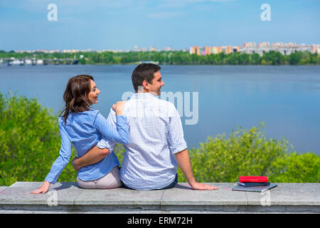 Jeune couple sur parapet à côté Banque D'Images