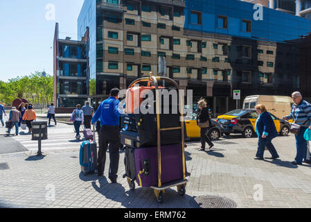 Groom poussant un chariot plein de bagages à l'entraîneur à Barcelone, Catalogne, Espagne Banque D'Images