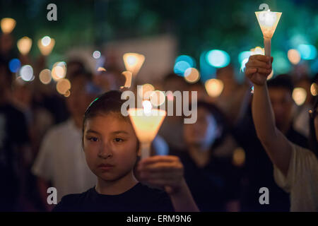 Les gens s'assoient ensemble comme ils commémorent la place Tiananmen 1989 incident au cours d'une veillée aux chandelles à Hong Kong le 4 juin 2015. Des dizaines de milliers de personnes ont pris part à l'événement pour commémorer le 26e anniversaire de la sanglante répression de la Place Tiananmen, la Chine tente d'oublier l'incident. Crédit : Antony Dickson/Alamy Live News Banque D'Images