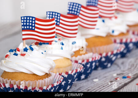 Rangée de 4 juillet patriotique sprinkles cupcakes avec des drapeaux américains et sur l'arrière-plan vintage Banque D'Images