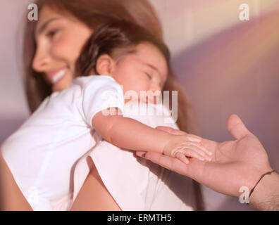 Cute adorable fille nouveau-né de dormir sur l'épaule de mères et père avec tendresse tenant sa petite main, concept d'amour Cute adorable fille nouveau-né de dormir sur l'épaule de mères et père avec tendresse tenant sa petite main, concept d'amour