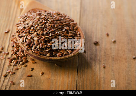 Les graines de lin tas sur une vieille cuillère en bois. Selective focus Banque D'Images