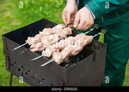 L'homme préparer la viande sur le grill, selective focus Banque D'Images