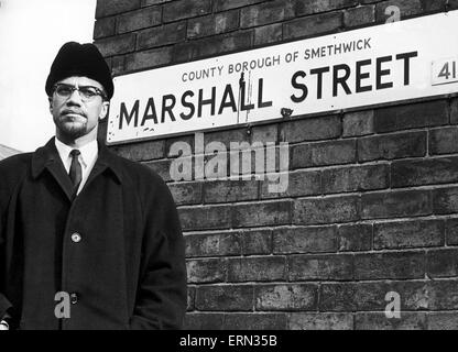 Malcolm X musulmans afro-ministre et militant des droits de l'homme pose à côté de la plaque de rue pour Marshall Street à Smethwick lors d'une visite à la région des Midlands. L'activiste des droits de l'homme posés à côté de la plaque signalétique, marché 50 mètres jusqu'à la rue, sourit Banque D'Images